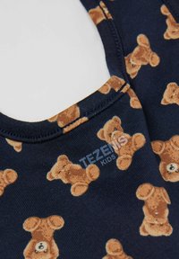 Tmavě modrá látka s vzorem medvídků v hnědé barvě. Výstřih je kulatý s viditelným šitím a je označen "TEZENIS KIDS."