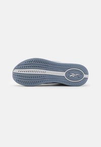 Shoe sole in light blue rubber with patterned tread, white midsole stripe, and circular logo; designed for traction and comfort.