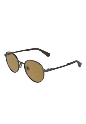 Okulary przeciwsłoneczne w stylu okrągłym z cienkimi czarnymi metalowymi oprawkami i brązowymi przyciemnianymi soczewkami, wyposażone w regulowane noski i smukłe zauszniki.