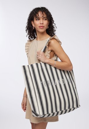 Borsa tote a righe in crema e nero, con la scritta "TERRANOVA". La borsa ha un design spazioso con manici spessi per un facile trasporto.