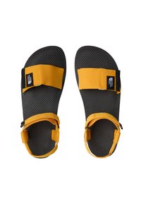 Svarta sandaler med texturerade sulor, utrustade med två justerbara gula nylonremmar och en svart varumärkesetikett på en av remmarna.