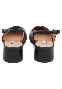 Le scarpe con tacco in pelle nera presentano un retro chiuso, una cintura regolabile e un interno liscio. I tacchi sono spessi e curvi per garantire stabilità.