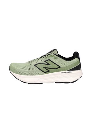 Zapatilla de running New Balance verde claro con acentos negros, parte superior de malla, suela blanca acolchada y la marca "Fresh Foam" en el lateral.
