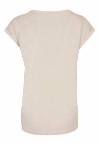 Lys beige kortærmet T-shirt lavet af blødt bomuld. Har en afslappet pasform og rund halsudskæring med op-rullede ærme detaljer.