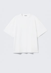 White oversized t-shirt made of cotton. Features short sleeves, a crew neckline, and subtle stitching details. Brand logo at neck.