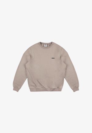 Beżowy sweatshirt wykonany z miękkiego materiału, z okrągłym dekoltem, długimi rękawami, ściągaczami na rękawach oraz małym czarnym logo na piersi.