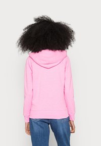 Sudadera de algodón rosa con capucha ajustable, puños acanalados y dobladillo. La parte posterior cuenta con una textura suave y elementos de diseño sencillos.