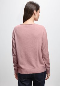 Helles rosa Sweatshirt mit lockerer Passform, geripptem Saum und Bündchen, weicher Textur und weitem Ausschnitt. Verfügt über lange Ärmel und ein lässiges Design.