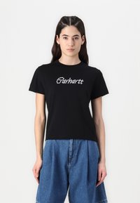 Černé bavlněné tričko s kontrastním logem Carhartt v bílé barvě, krátké rukávy, kulatý výstřih a volný střih. Nosené s denimovými šortkami.