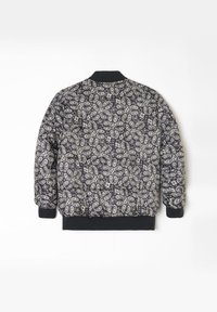 Veste bomber matelassée avec un motif paisley noir et blanc, poignets et ourlet côtelés, texture douce et col classique.