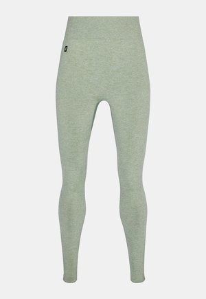 Leggings vert clair côtelés à taille haute et sans coutures, avec une petite étiquette logo noire sur la hanche gauche.