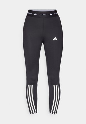 Leggings sportivi neri con un design aderente, dotati di un elastico in vita TECHFIT e tre strisce bianche sui polsini. Texture liscia.