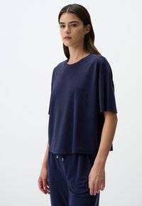T-shirt blu navy a maniche corte realizzato in morbido tessuto, con vestibilità ampia, scollo rotondo e dettagli di cucitura minimi.