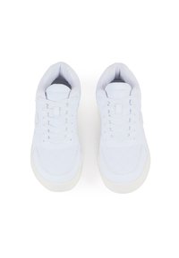 White sneakers with a quilted pattern, smooth finish, lace-up design, and a contrasting light gray logo on the tongue. Rubber sole.