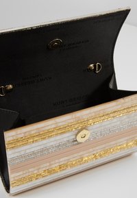 Liten öppen kuvertväska med guld-, silver- och beige-ränder samt svart innerfoder tryckt med "Kurt Geiger London" och en guldknäppning.