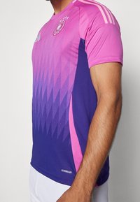Jersey deportivo de manga corta en degradado rosa y púrpura, con un patrón geométrico, tres franjas en los hombros y el logo "AEROREADY".