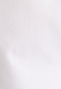 White fabric with a smooth, slightly textured surface, showcasing a uniform color without patterns or embellishments.