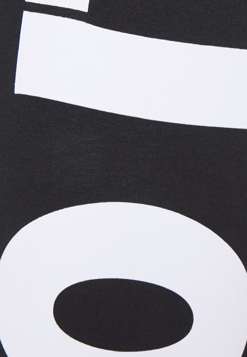 Schwarzer Stoff mit auffälligem, weißem Grafiktext, einschließlich horizontaler Streifen, großen kreisförmigen Formen und einer strukturierten Oberfläche.