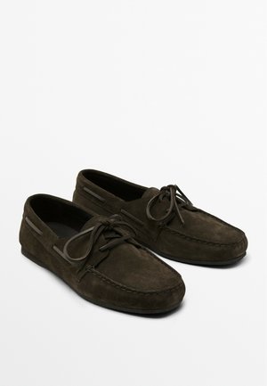 Dark green suede moccasin shoes feature a round toe, lace-up front, stitching detail, and subtle side accents. Soft texture with a flat sole.