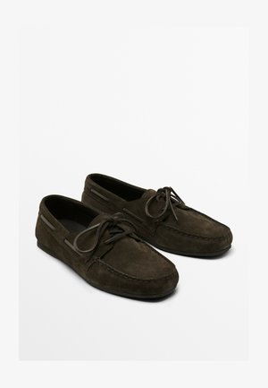 Dark green suede moccasin shoes feature a round toe, lace-up front, stitching detail, and subtle side accents. Soft texture with a flat sole.