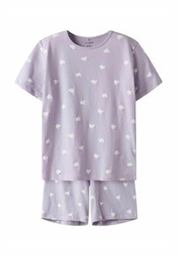 Ensemble de pyjama lilas en tissu doux, comprenant un haut à manches courtes ornée de motifs de cœurs blancs et un short assorti au même design.