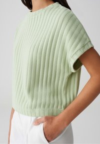 Lys grøn ribbet sweater med rund halsudskæring, korte ærmer og en cropped pasform. Har en tekstureret strik og lige kant.