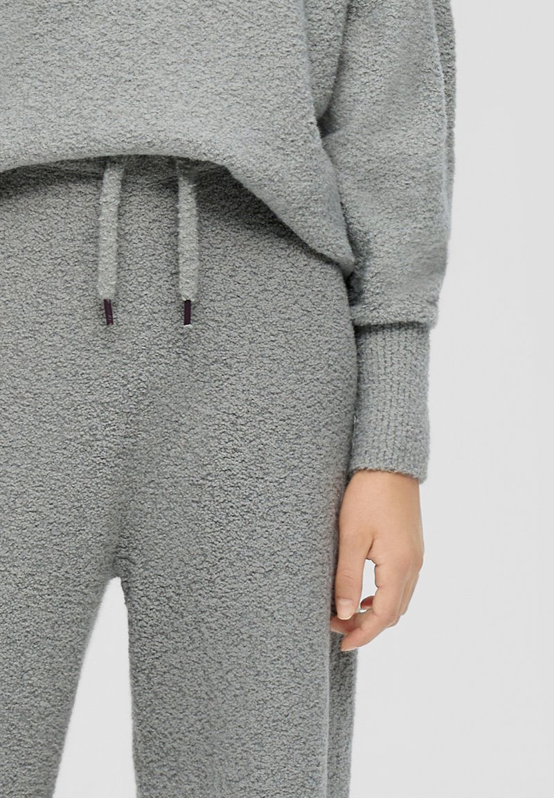 Grijs fleece lounge set met een gestructureerde, zachte afwerking. De top is losvallend met een trekkoord; de broek is relaxed met elastische boorden.