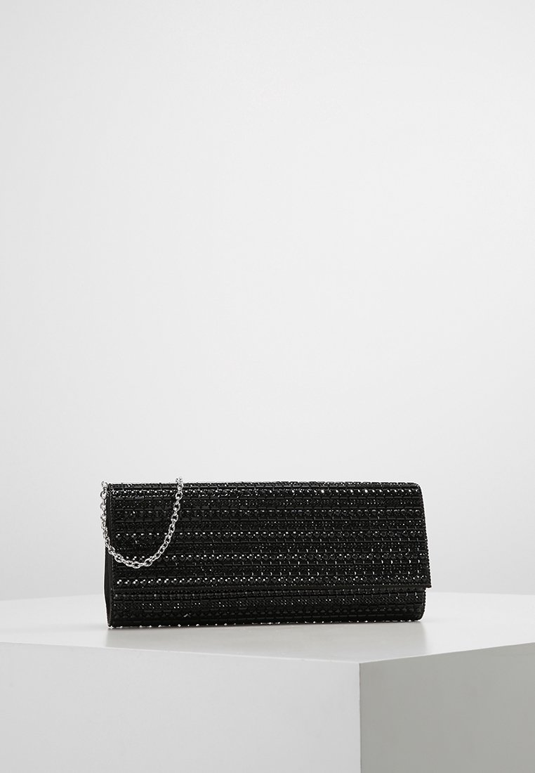 Pochette rectangulaire noire avec surface perlée texturée et courte chaîne argentée reposant sur une plateforme blanche sur fond uni.