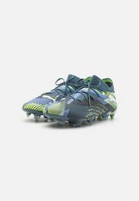 Scarpe da calcio eleganti e leggere con un motivo blu, verde e nero, materiale testurizzato e tacchetti sagomati per una migliore trazione.