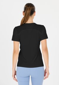 Sort atletisk T-shirt med korte ærmer, der har en glat tekstur og en buet kant. Bagud viser den et enkelt design uden mønstre.