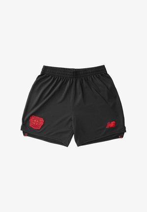 Pantalones cortos deportivos negros hechos de tela transpirable, con un logo de club rojo en la parte frontal izquierda y un logo rojo de New Balance en la parte inferior derecha.