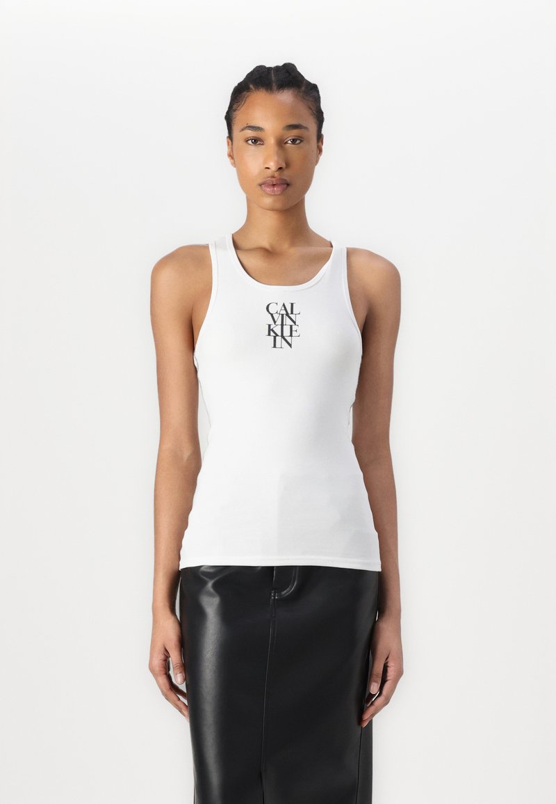Top bianco senza maniche con scollatura rotonda, caratterizzato da un logo grafico nero centrato sul davanti. Materiale in cotone morbido, design aderente.