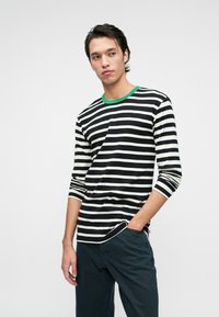 Camisa de manga longa com riscas, apresentando riscas horizontais em preto e branco, colarinho verde, material macio e ajuste descontraído.