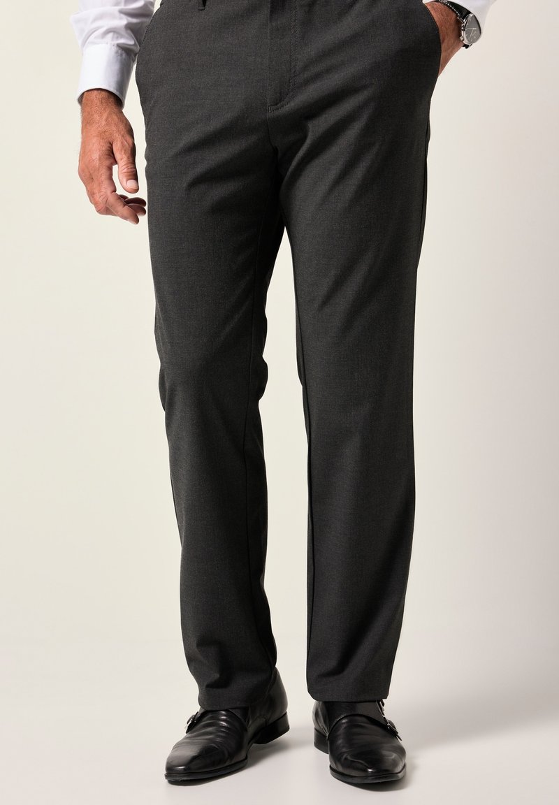 Pantalones de vestir grises con tela texturizada, diseño de pierna recta y pliegues planchados. Combinados con zapatos de cuero negros.