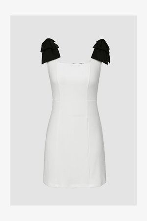 White short dress with square neckline, textured fabric, and black ruffled accents on shoulder straps. Form-fitting design with clean lines.