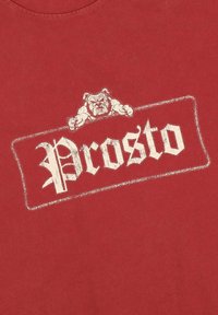 Czerwona bawełniana koszulka z grafiką białego buldoga nad napisem "Prosto" w stylu vintage, umieszczonym w prostokątnym obramowaniu.