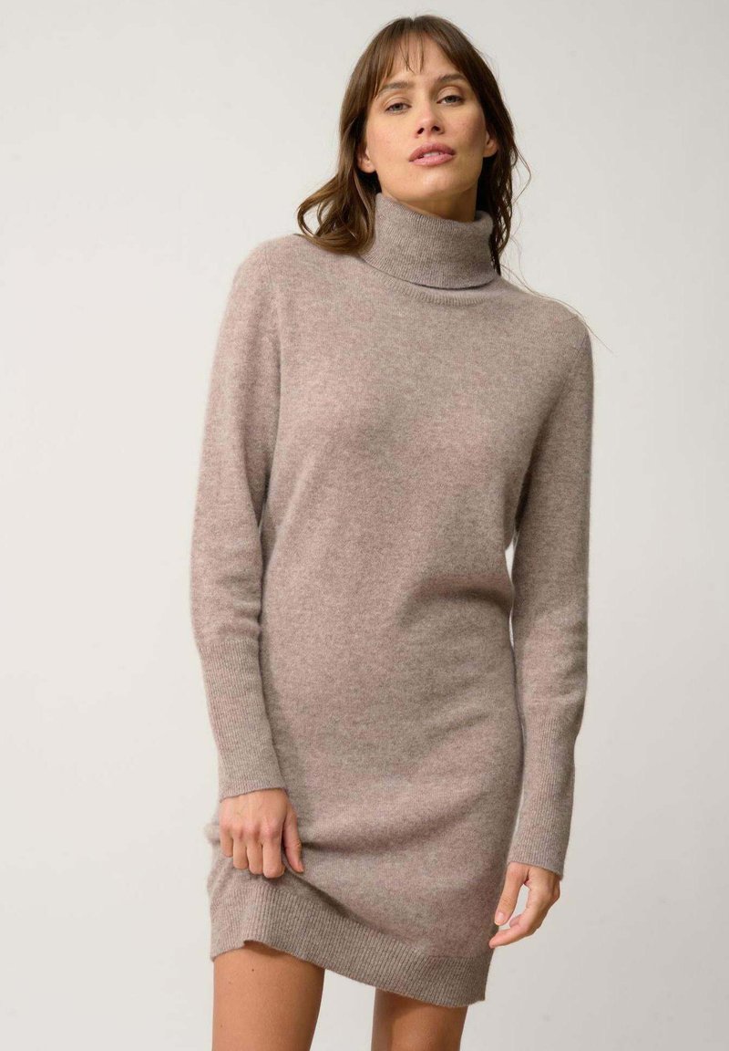 Vestito maglione a collo alto in morbido tessuto color marrone chiaro. Maniche lunghe, polsini e orlo a costine, silhouette aderente e texture liscia.