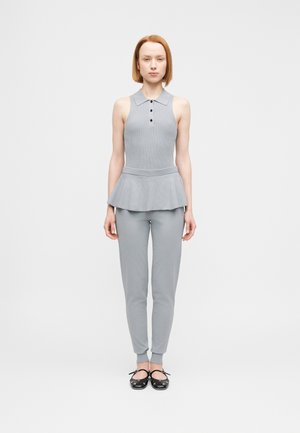 Siv brezrokavnik z ovratnikom in detajlom na gumbih, v kombinaciji z ujemajočimi se ožjimi hlačami. Gladek tekstura, sodoben silhuet, minimalističen dizajn.