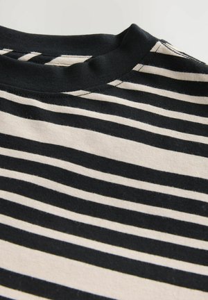 T-shirt en coton noir et crème à rayures, avec un col rond, des manches courtes et une texture douce avec des motifs horizontaux uniformes.