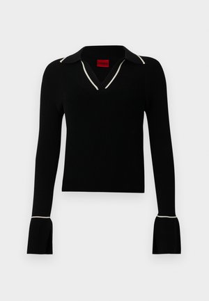 Svart ribbet langermet topp med V-hals og hvit kragekant. Har vidgolfte mansjetter og en tettsittende design. Rødt merkelapp innvendig.