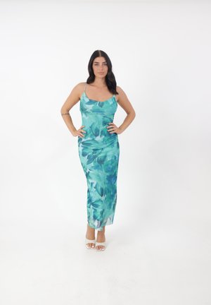 Une robe longue et ajustée avec un motif floral dans des teintes de bleu canard et de vert, complétée par de fines bretelles et un tissu lisse et léger.