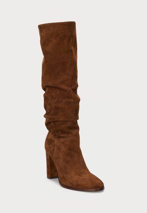 Brown suede knee-high boots with a pointed toe and chunky heel. Textured with gathered detailing and a smooth finish.