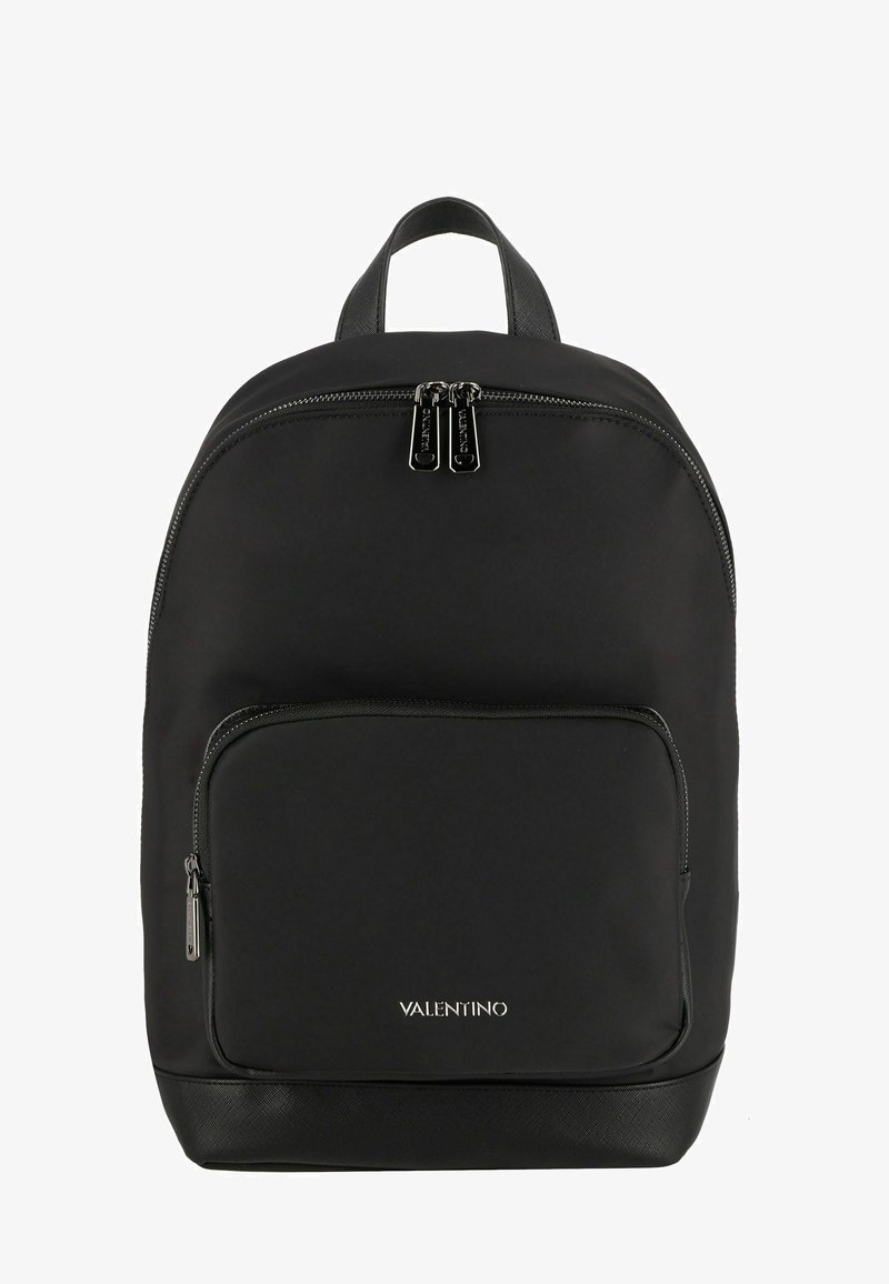 Sac à dos en nylon noir avec deux compartiments zippés, une poignée supérieure et un fond texturé noir. Présente des accessoires en métal argenté et un détail de logo.