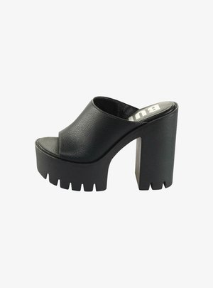 Black platform mules with a textured leather upper, open toe, and a chunky, ridged heel. Simple design with a smooth interior lining.