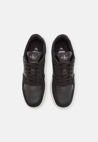 Zapatillas deportivas negras con materiales de cuero y ante, detalle en la punta perforado, collar acolchado y suela de goma blanca. Logo de Calvin Klein en la lengüeta.
