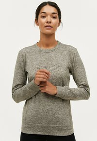 Grå langærmet sweatshirt med et struktureret geometrisk mønster på brystet, rund halsudskæring og ribbede manchetter. Letvægtigt stof med en blød overflade.