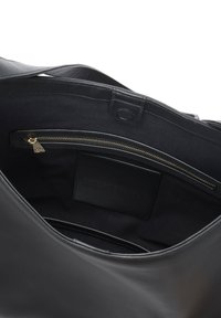 Sac fourre-tout en cuir noir avec une poche zippée, texture lisse et détails en couture. L'intérieur est doublé de tissu avec une poche plate.