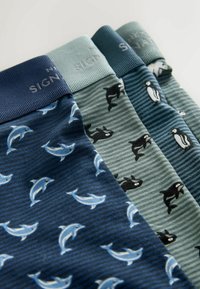 Trzy pary skarpet: granatowe z wzorem delfinów, zielone z motywem orki, ciemnoniebieskie z pingwinami, z prążkowanymi ściągaczami i miękką bawełnianą fakturą.