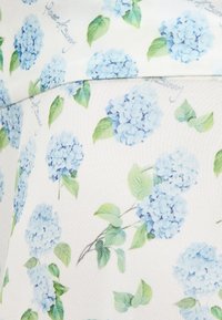 Λευκό ύφασμα με σχέδιο επαναλαμβανόμενων συστάδων λουλουδιών υδραγείων σε ανοιχτό μπλε και πράσινα φύλλα.