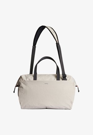Sac polochon beige clair en tissu résistant, doté de deux poignées courtes et d'une bandoulière amovible avec une surface en mesh pour plus de confort.